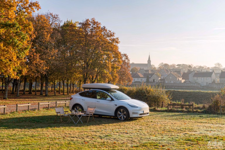 White Tesla Model Y with a rooftop tent on a grass pitch at a French campsite on an autumn morning